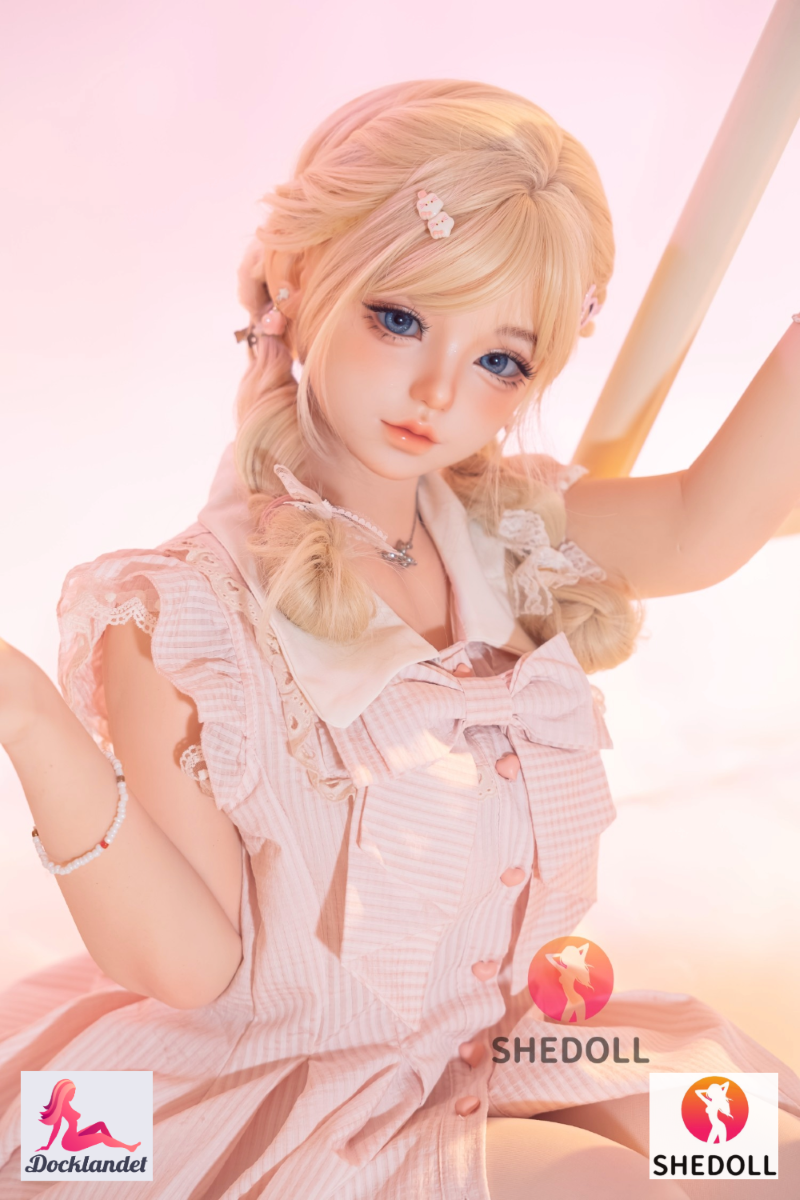 Sandy SHEDOLL 152 cm, istub roosas volangis kleidis, naturaalne A-tass, kerge pastelne keskkond.